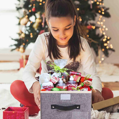 Young girl opening a gift box with a Christmas tree in the background