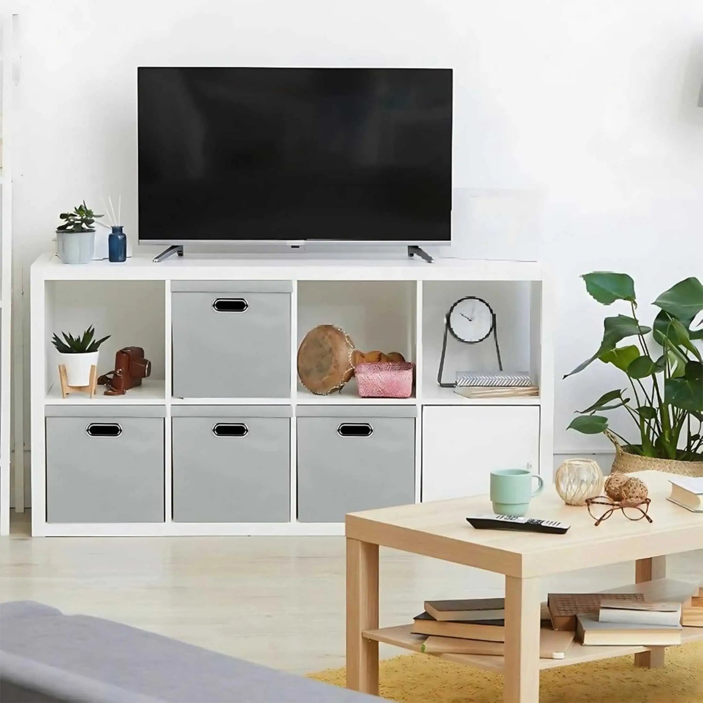 Grey foldable storage boxes organizing a living room shelf, showcasing versatile collapsible storage.