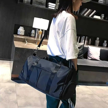 Person using the shoulder strap on a mens gym duffle bags, a perfect workout duffle bag for travel.